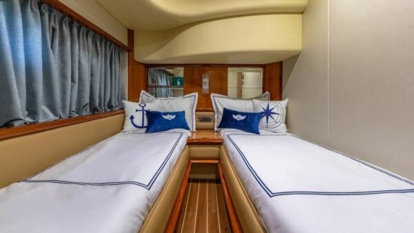 Guest cabin of the 62' AZIMUT REGAL yacht with twin beds, offering comfort and luxury for guests