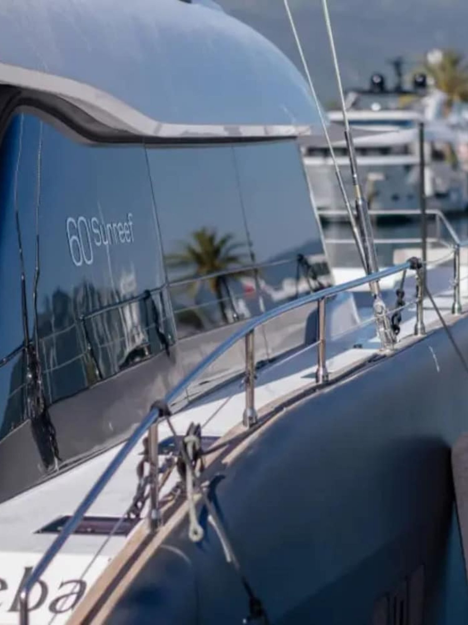 A luxurious Sunreef 60 yacht anchored in crystal-clear waters, displaying its sleek design.