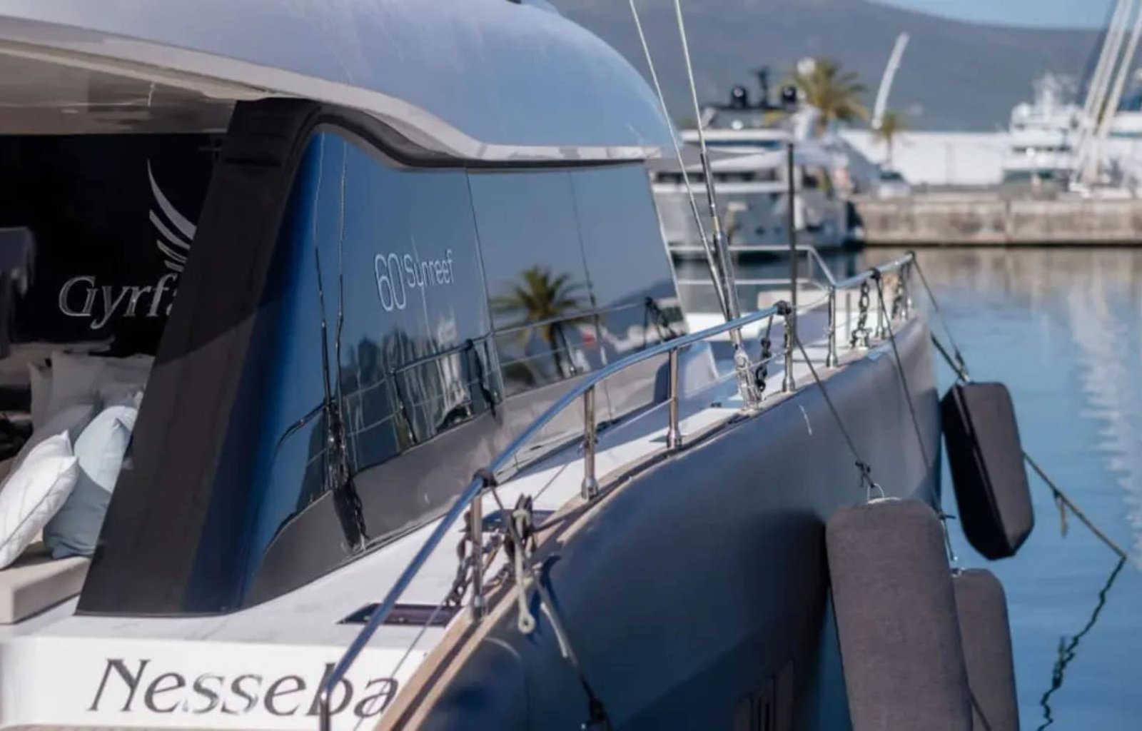 A luxurious Sunreef 60 yacht anchored in crystal-clear waters, displaying its sleek design.