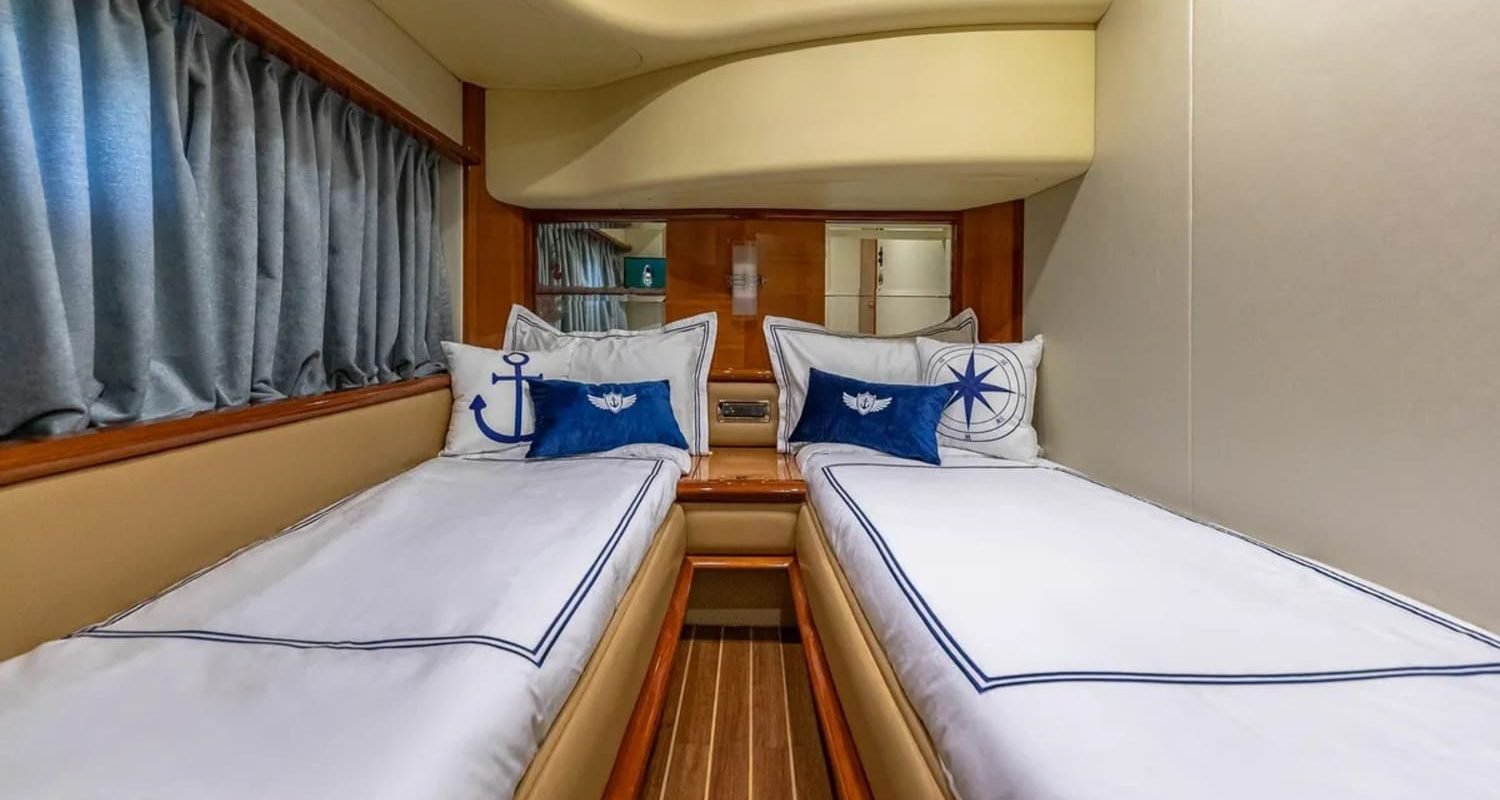 Guest cabin of the 62' AZIMUT REGAL yacht with twin beds, offering comfort and luxury for guests