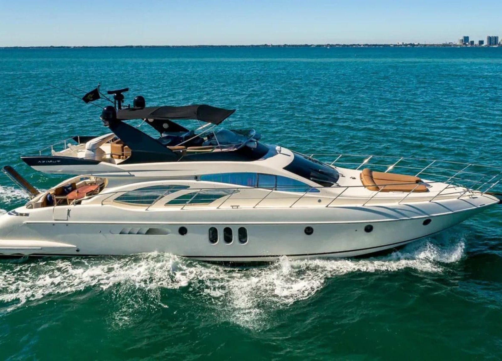 62' AZIMUT REGAL yacht sailing on the water, showcasing its elegant design and superior performance in a luxurious setting.