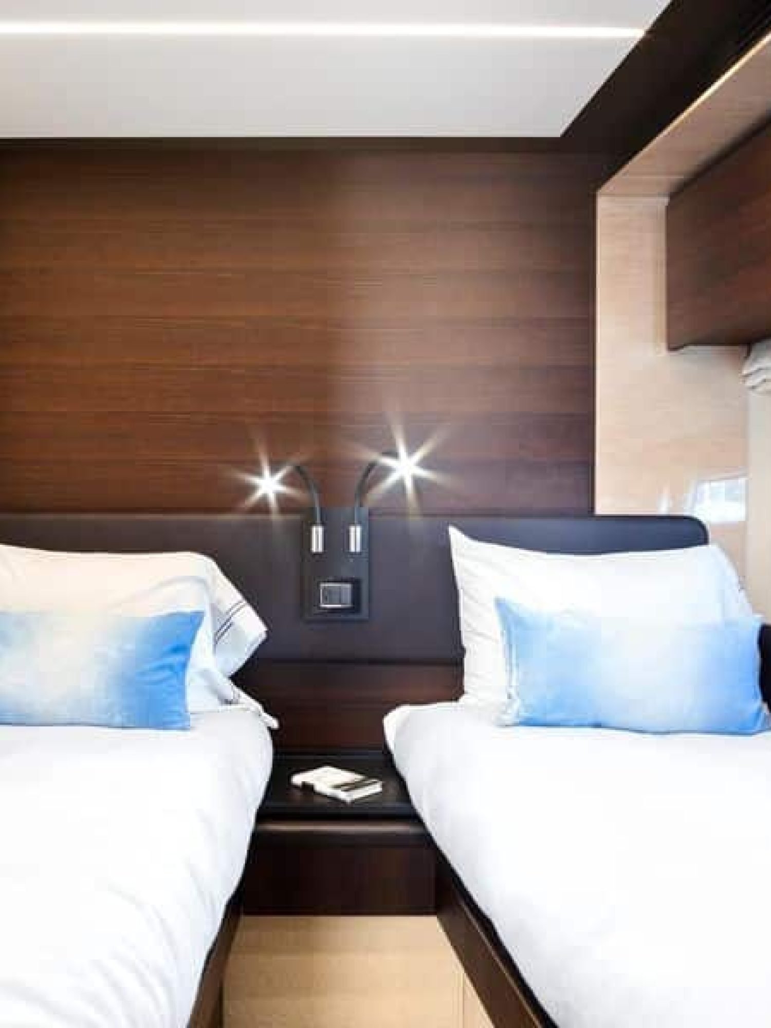 Interior view of the twin-bed cabin inside the 72' Azimut Flybridge yacht, featuring two comfortable beds, soft ambient lighting, and modern decor for a relaxing stay.