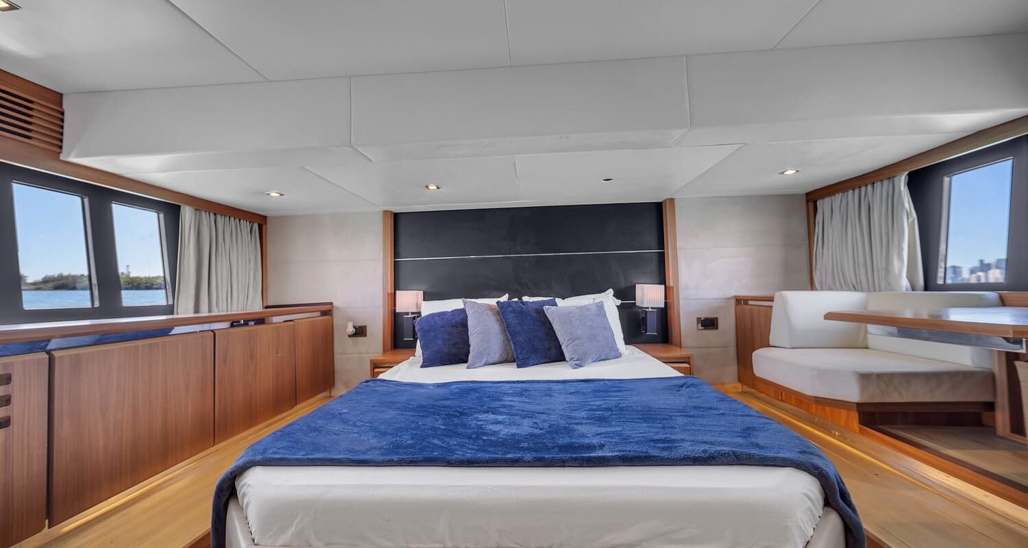 View of the 60' Absolute Fly yacht's guest bedroom with a queen-sized bed and elegant furnishings.