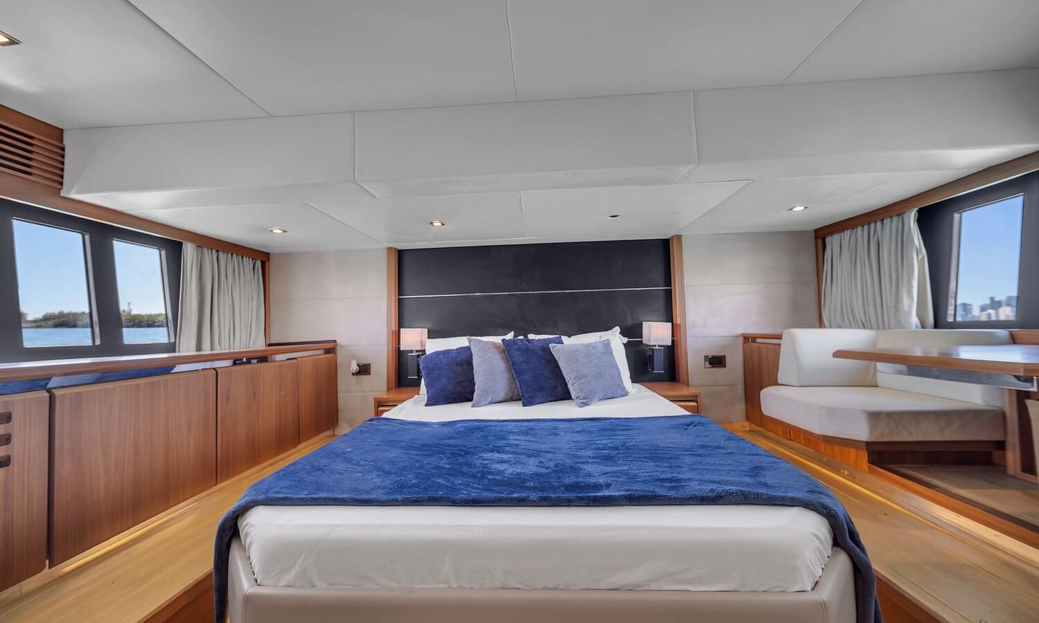 View of the 60' Absolute Fly yacht's guest bedroom with a queen-sized bed and elegant furnishings.