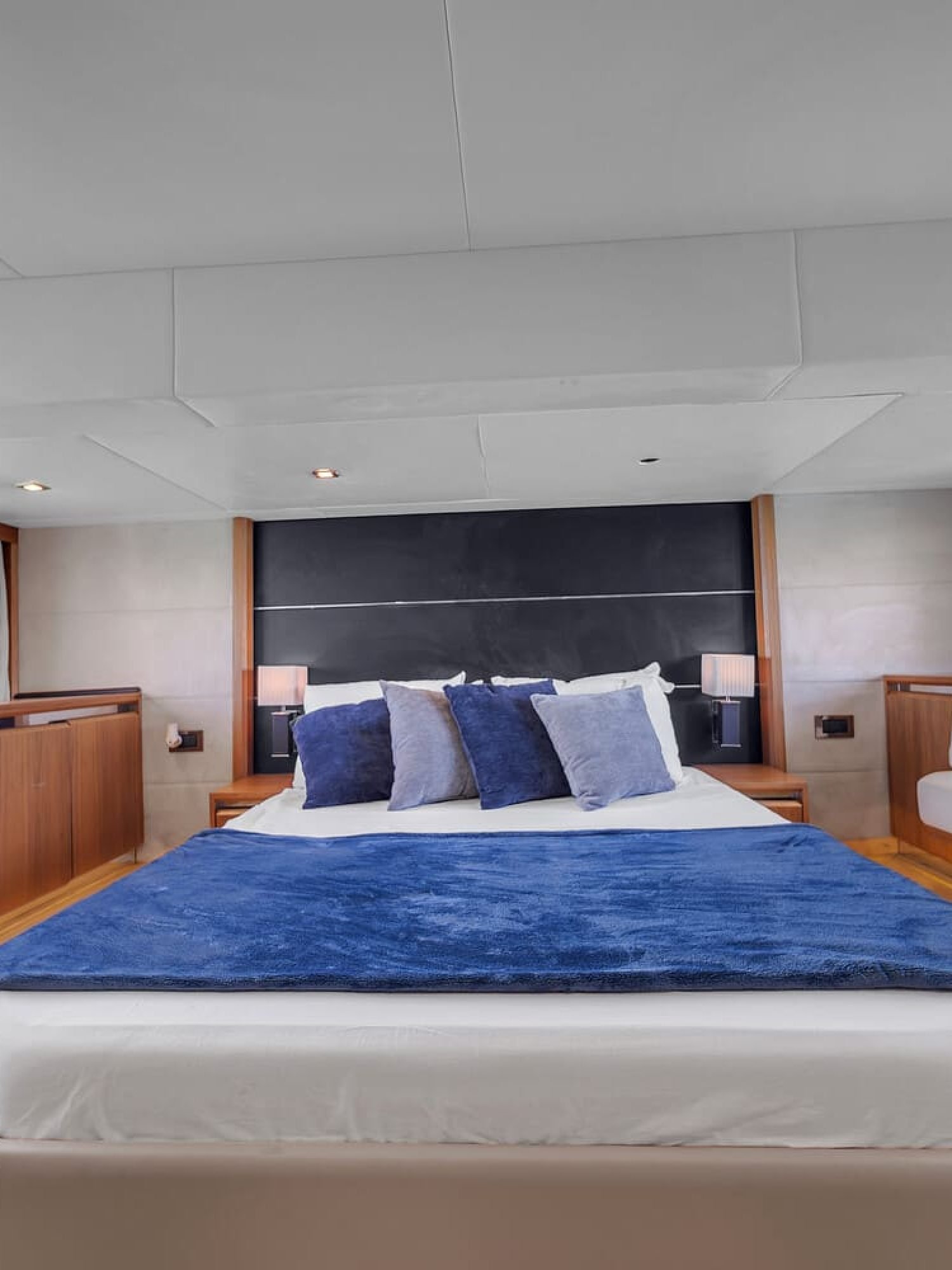 View of the 60' Absolute Fly yacht's guest bedroom with a queen-sized bed and elegant furnishings.