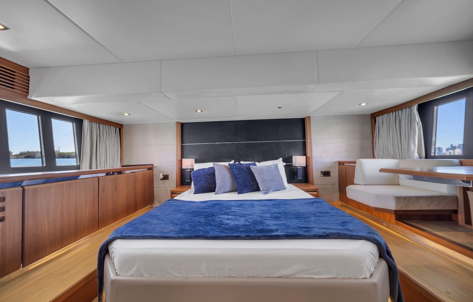View of the 60' Absolute Fly yacht's guest bedroom with a queen-sized bed and elegant furnishings.