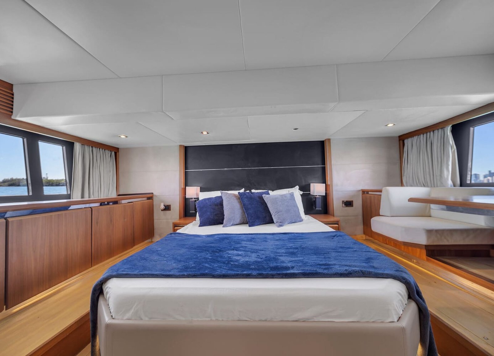 View of the 60' Absolute Fly yacht's guest bedroom with a queen-sized bed and elegant furnishings.